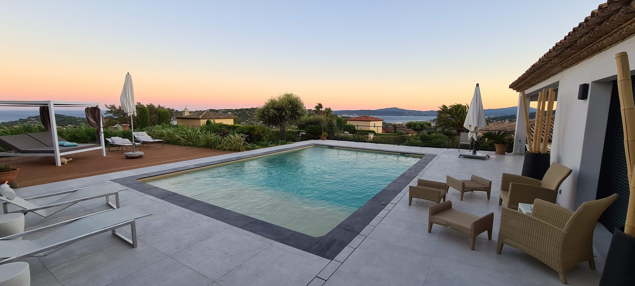 Piscina y terraza al anochecer sobre el golfo